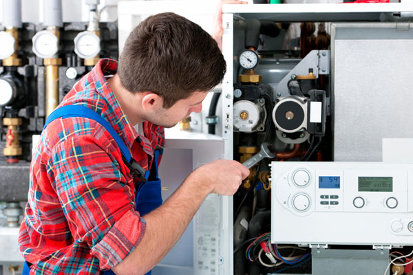 Heating technician repairing boiler controls in Belmont