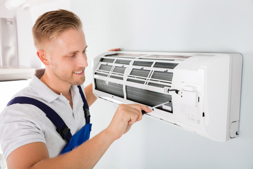 HVAC technician maintaining a ductless air conditioner in Belmont
