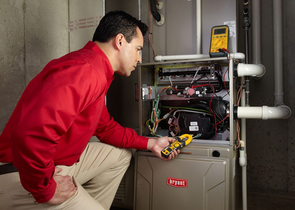 Heating technician diagnosing a furnace repair in Belmont