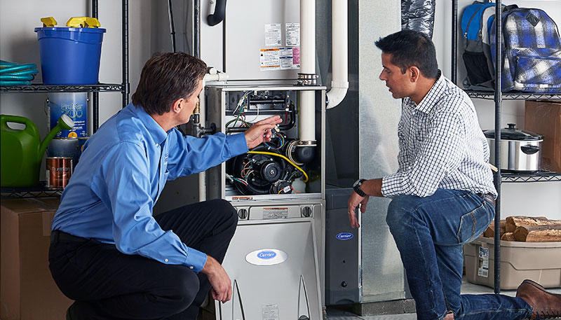 Technician evaluating a furnace for repair or replacement in Belmont